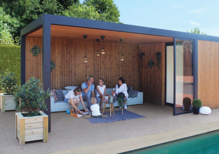 family resting under an aura pod in a garden by the pool